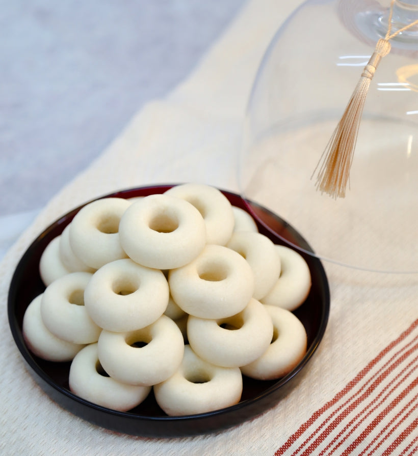 White donut-shaped kaak warka on a black plate with a blurred background