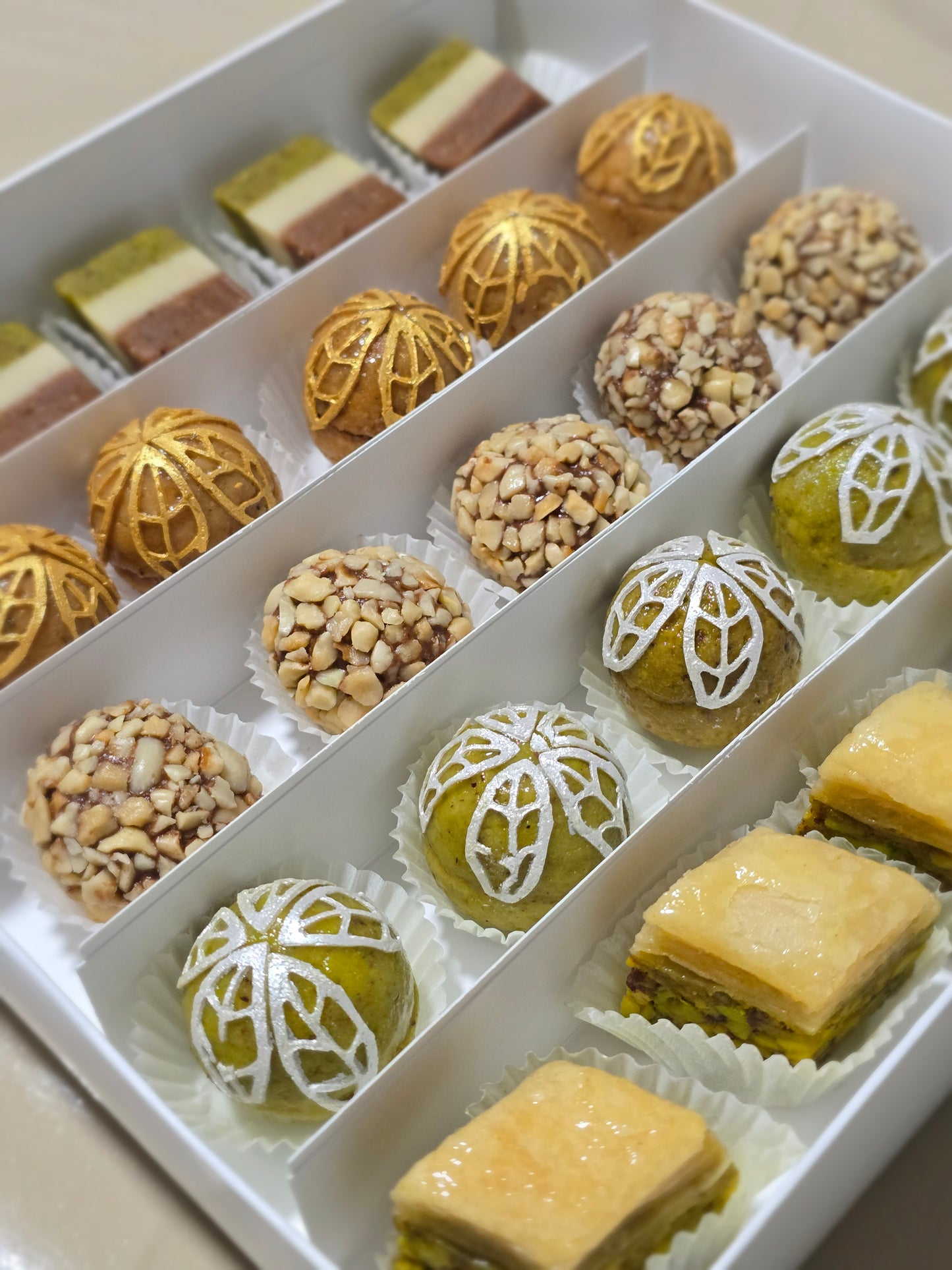 Assorted pastries including nuts and decorative cookies on a white tray.