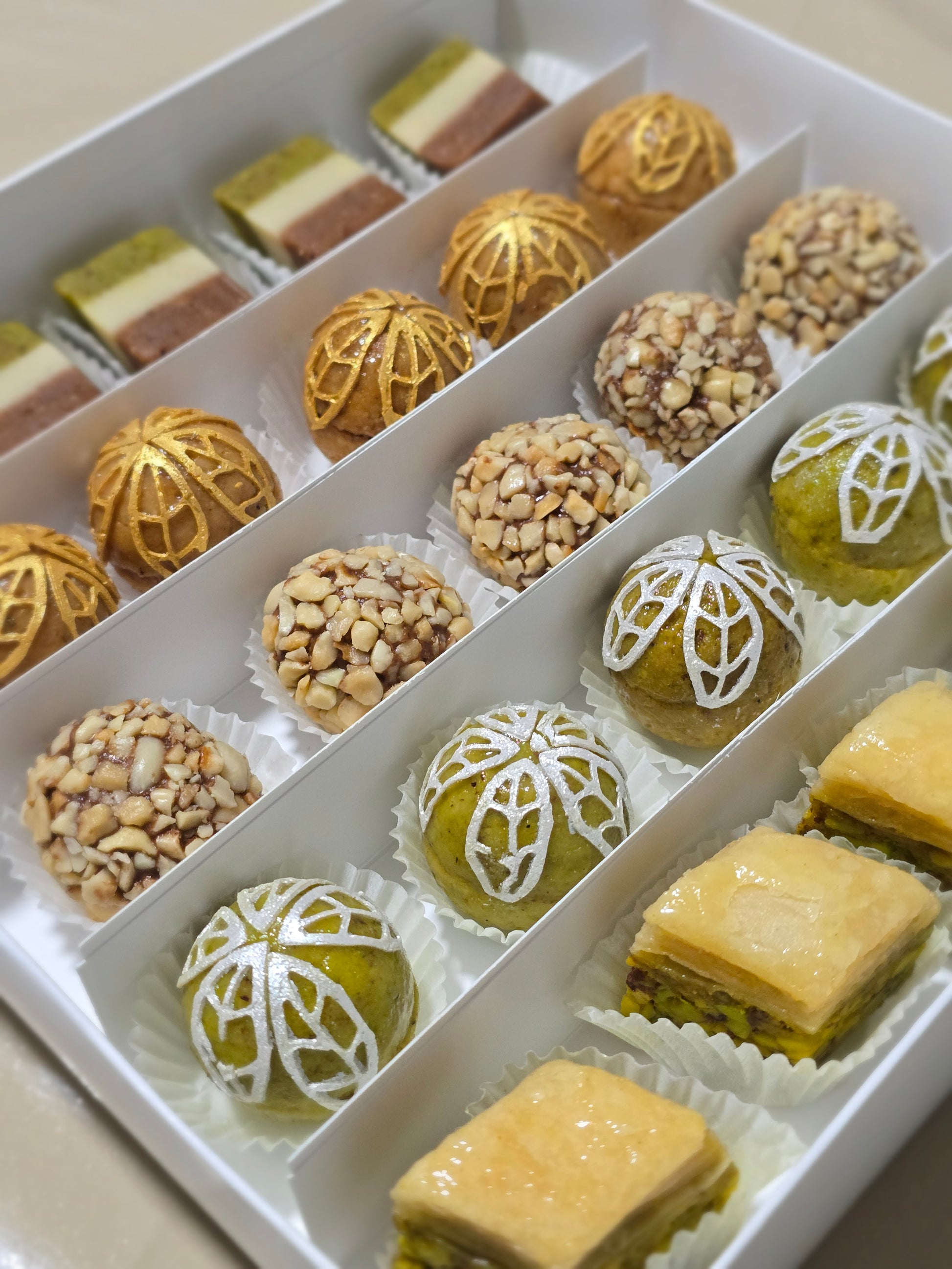 Assorted pastries including nuts and decorative cookies on a white tray.